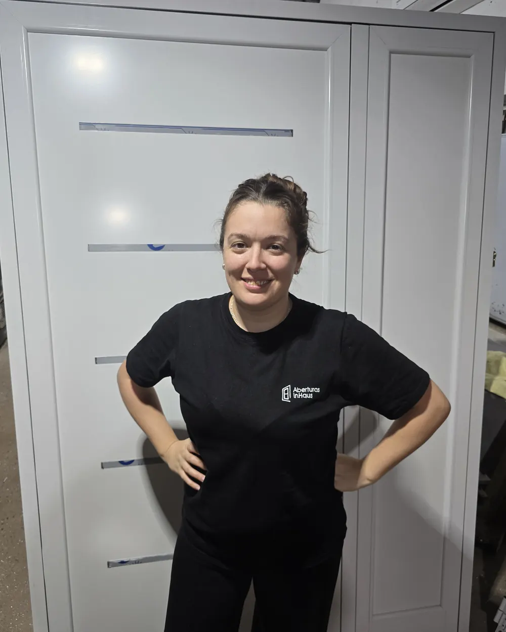 Yesi, de InHaus, en el taller, con la remera de la marca delante de una puerta blanca